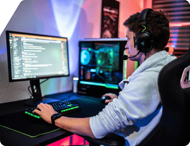Man sitting at a computer with headphones on playing a game.