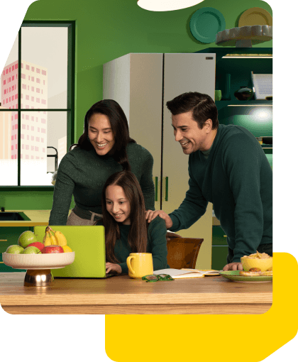 Happy family smiling in their kitchen looking at a laptop
