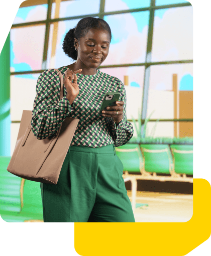 A woman in the airport smiling looking at her phone.