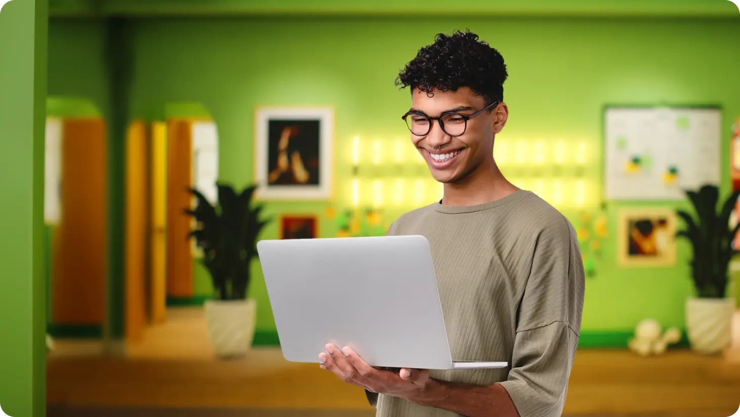 Smiling young man typing on laptop PC.
